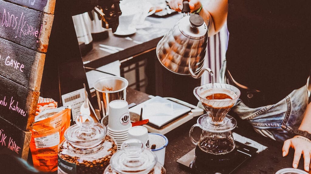 Coffee shop barista making a pour over - the best person to ask if they serve ethical, sustainable coffee