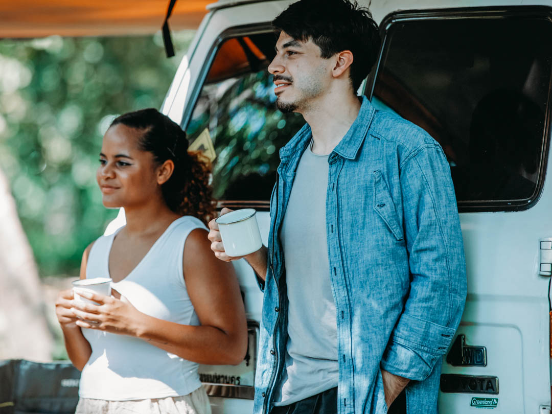 A couple enjoying coffee whilst camping, thanks to their portable battery powered coffee maker