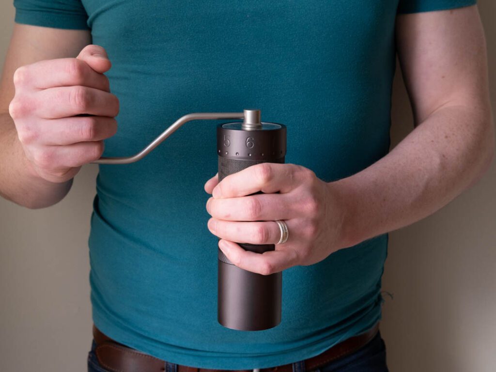 Man holding 1zpresso J max coffee grinder