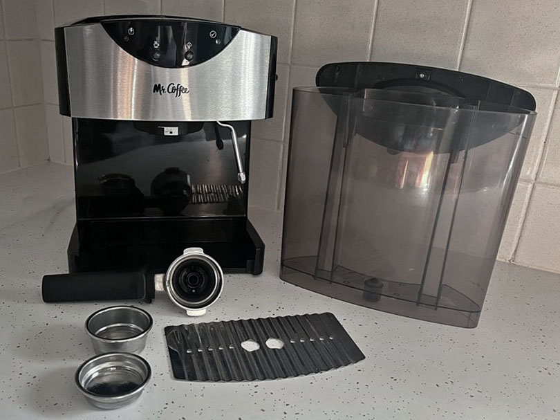 Mr Coffee ECMP50 with the portafilter, filter baskets, drip tray, and water tank lying separately on kitchen counter