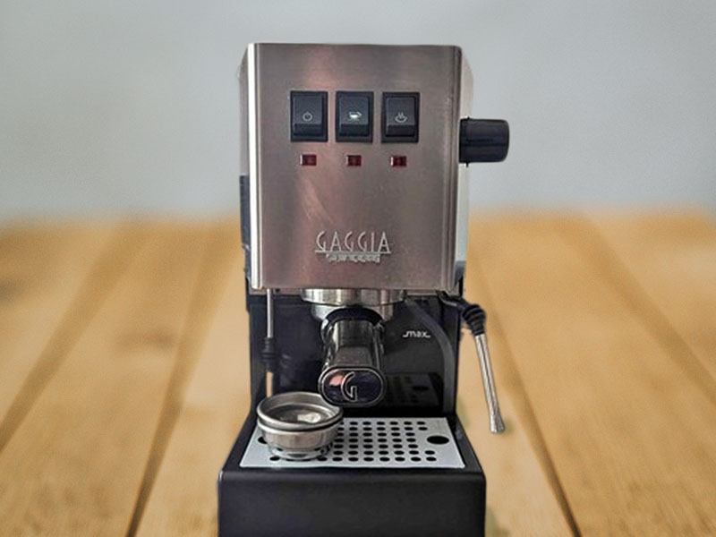 Gaggia Classic Evo Pro on wooden table with filter baskets sitting on the drip tray