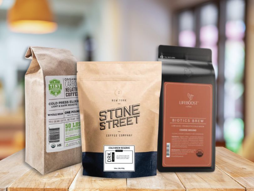 Selection of the best cold brew coffee beans - bags of Tiny Footprint, Stone Street, and Lifeboost Biotics Brew sitting on table