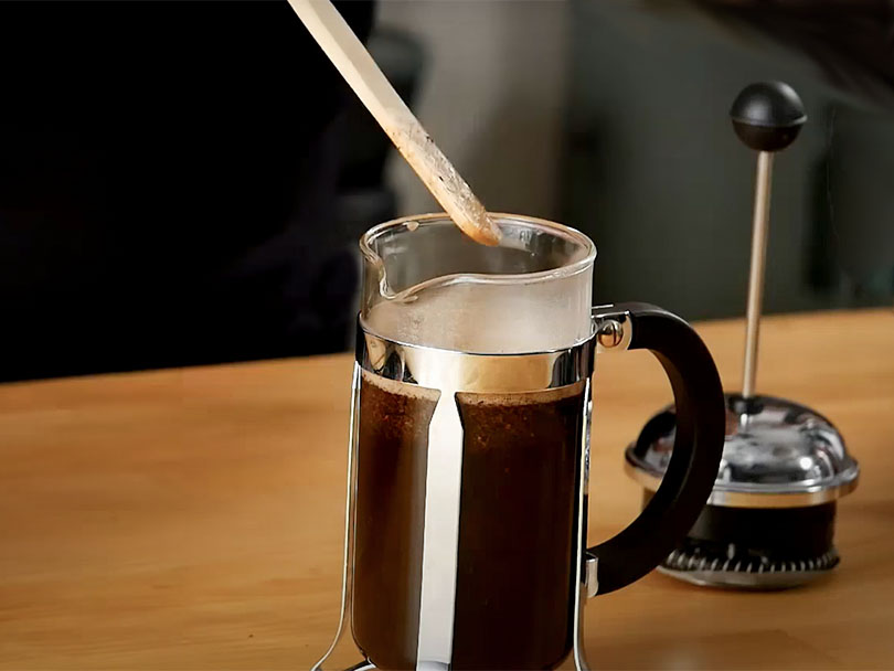 Stirring French Press coffee with a bamboo paddle