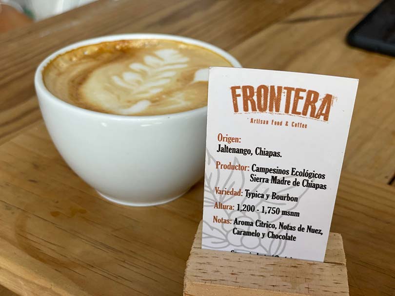A cappuccino made with single-origin coffee beans from Chiapas, Mexico (description of the beans beside the cup)