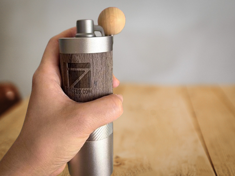 Man's hand holding the 1Zpresso Q2 grinder