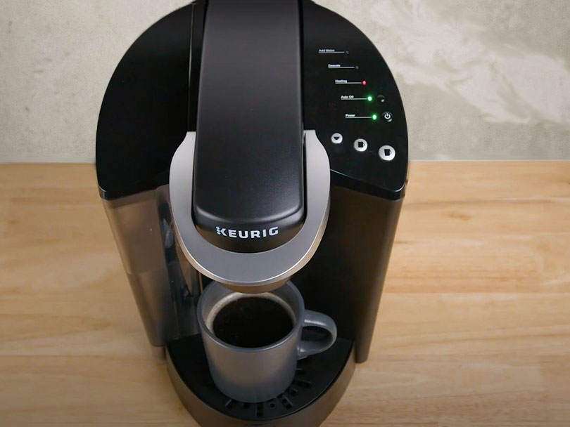 Freshly made cup of black coffee sitting on the Keurig K-Classic's drip tray