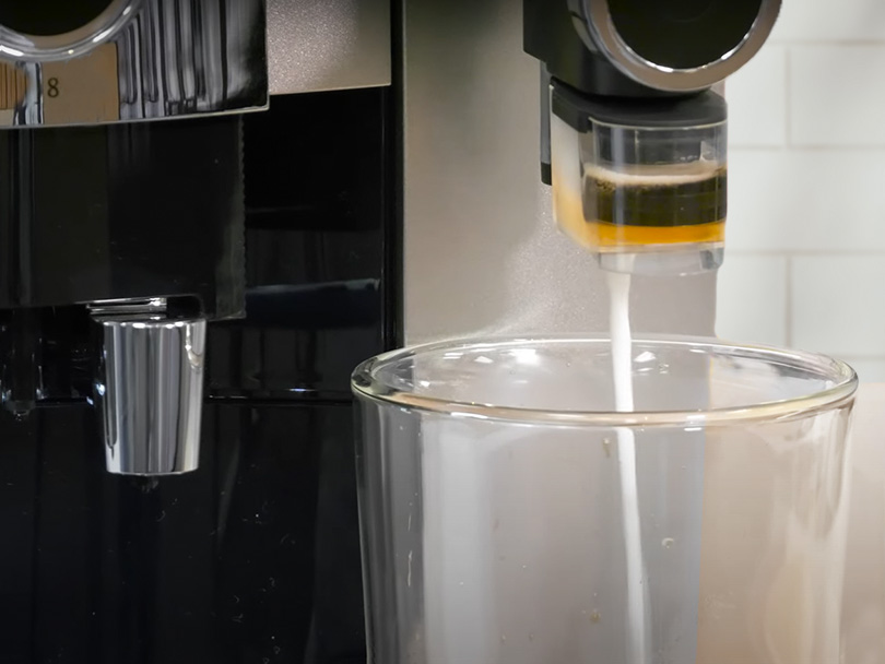 Close-up of the Jura J8 syrup cartridge dispensing sweet milk foam into cup