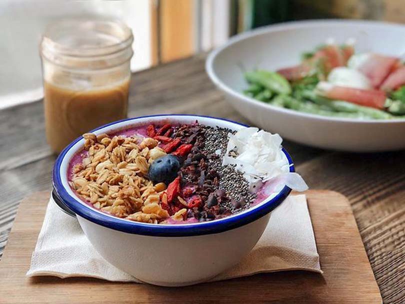 Protein coffee as part of a balanced meal with a smoothie bowl and salad