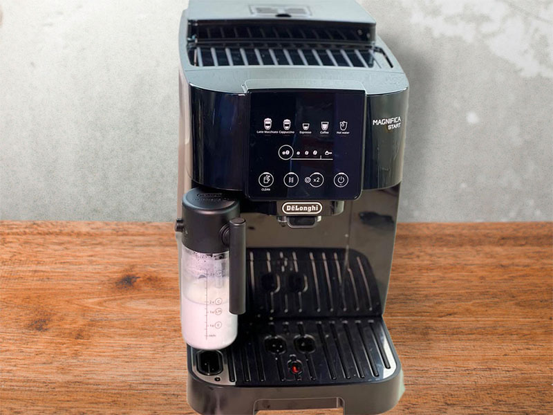 DeLonghi Magnifica Start (black) with LatteCrema sitting on a wooden counter