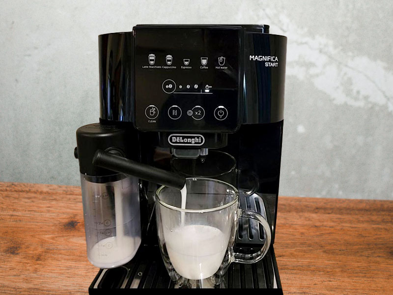 DeLonghi Magnifica Start pouring milk into a waiting cup