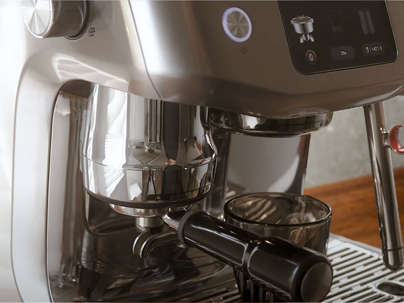 Side view of the Breville Oracle Jet midway through auto-dosing and tamping the freshly ground coffee