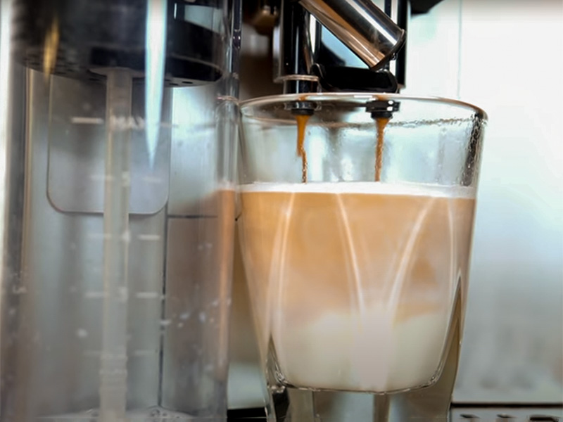 DeLonghi Magnifica Plus in the middle of making a latte