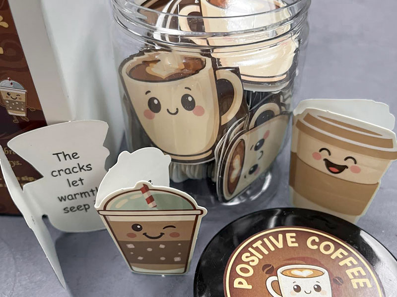 A jar filled with coffee affirmations, and a few scattered on the table