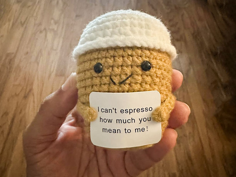 Hand holding a crochet coffee cup gift with positive affirmation 'I can't espresso how much you mean to me!'