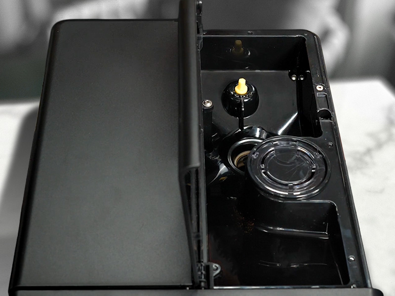 Top-down view of the grinder, grind adjustment dial and pre-ground coffee chute of the Gaggia Magenta Prestige