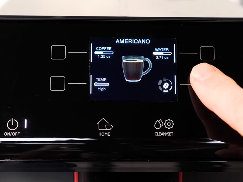 Finger pointing at the Gaggia Magenta Presige UI displaying all the adjustable settings for making an americano
