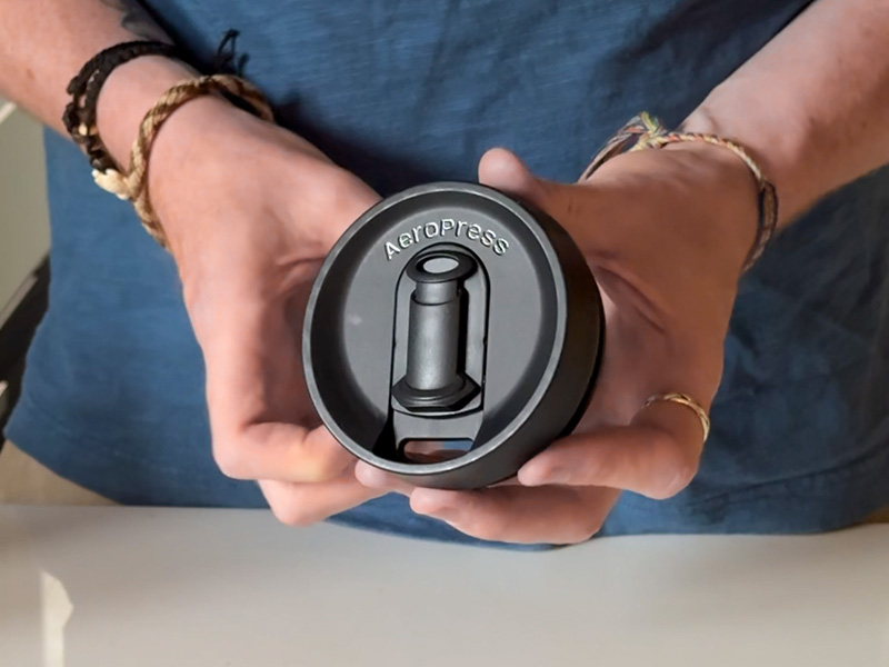 Holding the branded AeroPress Go Plus lid