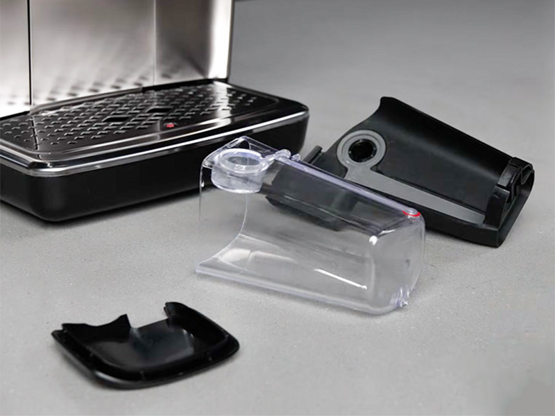 The two parts plus lid of the Philips 3300 LatteGo milk system laid out on kitchen counter in front of the machine