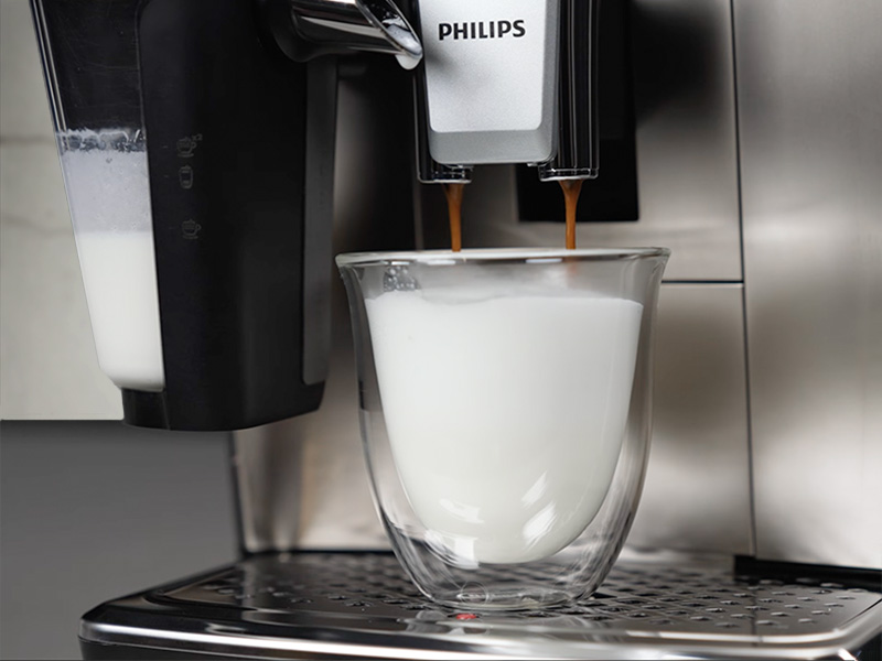 Philips 3300 pouring a shot of espresso into freshly steamed glass of milk