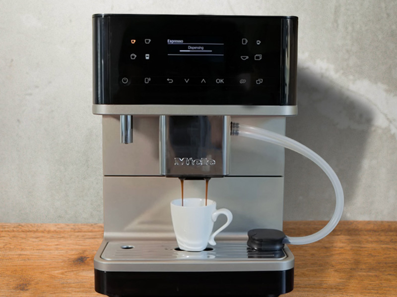 Miele CM 6360 mid-way through dispensing a single espresso into waiting white cup
