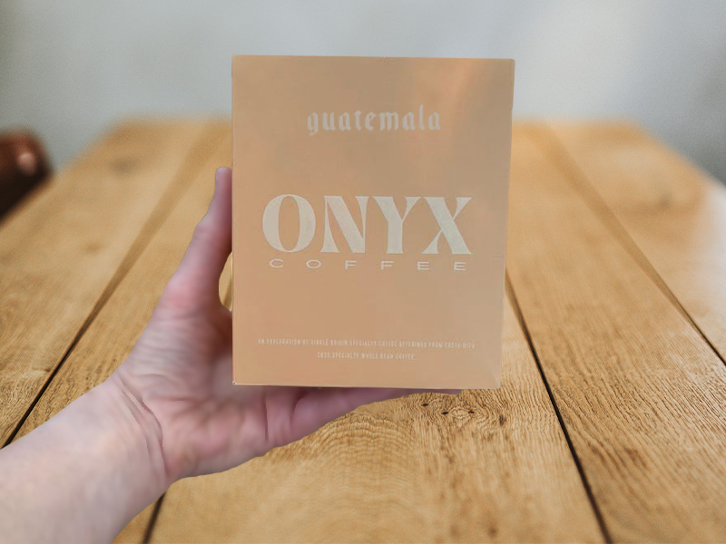 Hand holding a box of Onyx Coffee from Guatemala