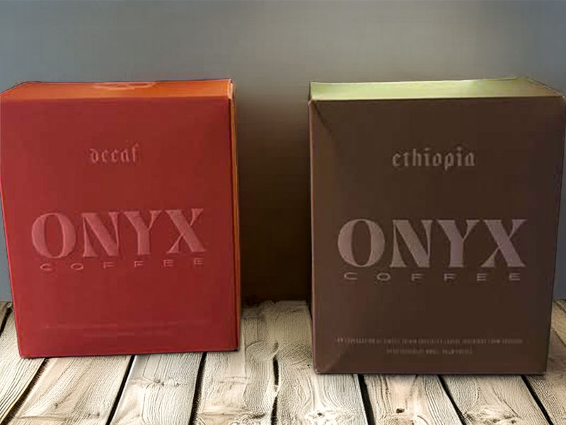 Two boxes of coffee on wooden table - Onyx Decaf Coffee & Ethiopian Coffee