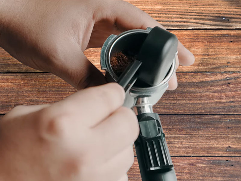 Putting ground coffee into the Sowtech espresso machine's filter basket