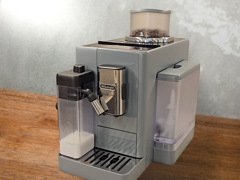 DeLonghi Rivelia (pebble gray) sitting on a wooden table