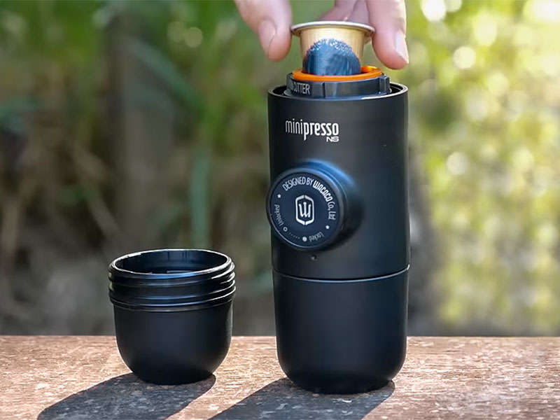 Placing a Nespresso pod into chamber of Wacaco Minipresso
