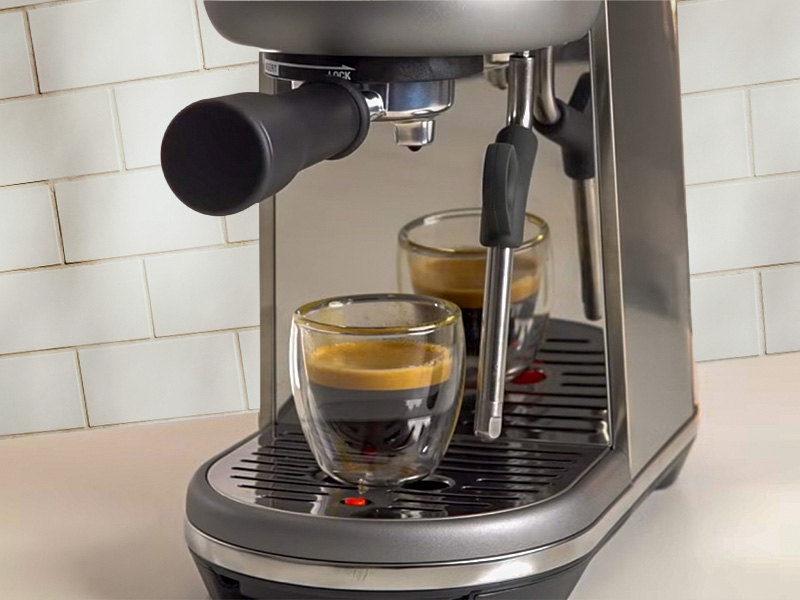 Fresh shot of espresso sitting on the Breville Bambino drip tray