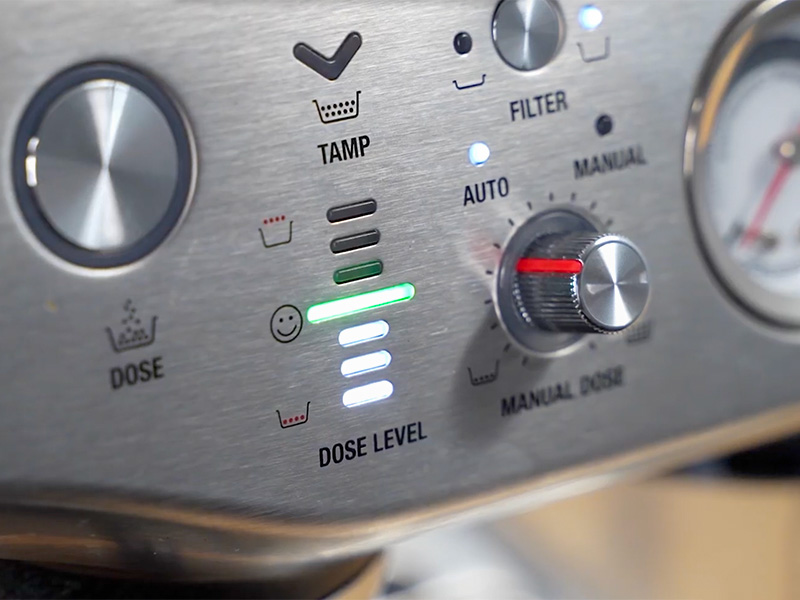 Close-up of the front of the Breville Barista Express Impress showing the dose level lights of the Impress auto puck system