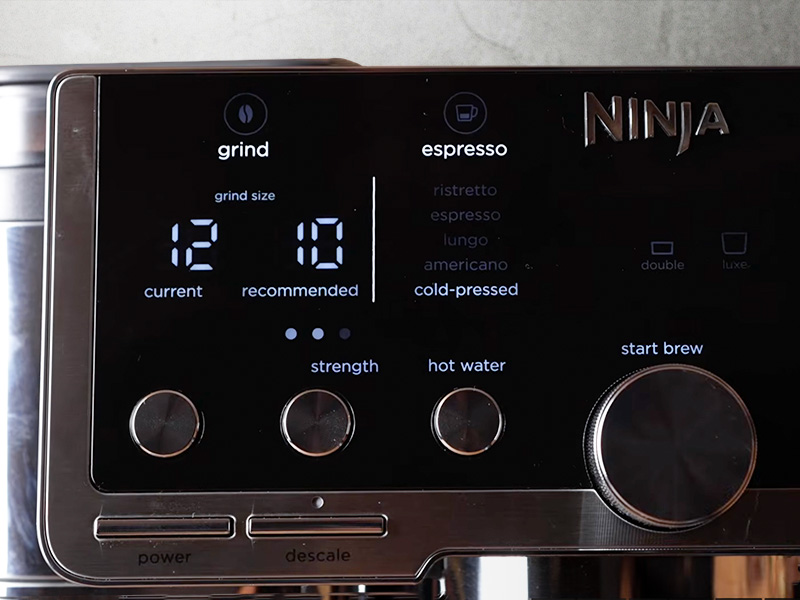 Close-up of the Ninja Luxe Cafe Pro user interface showing the Barista Assist with current grind setting 12, recommended setting 10, the list of espresso drinks options is to the side