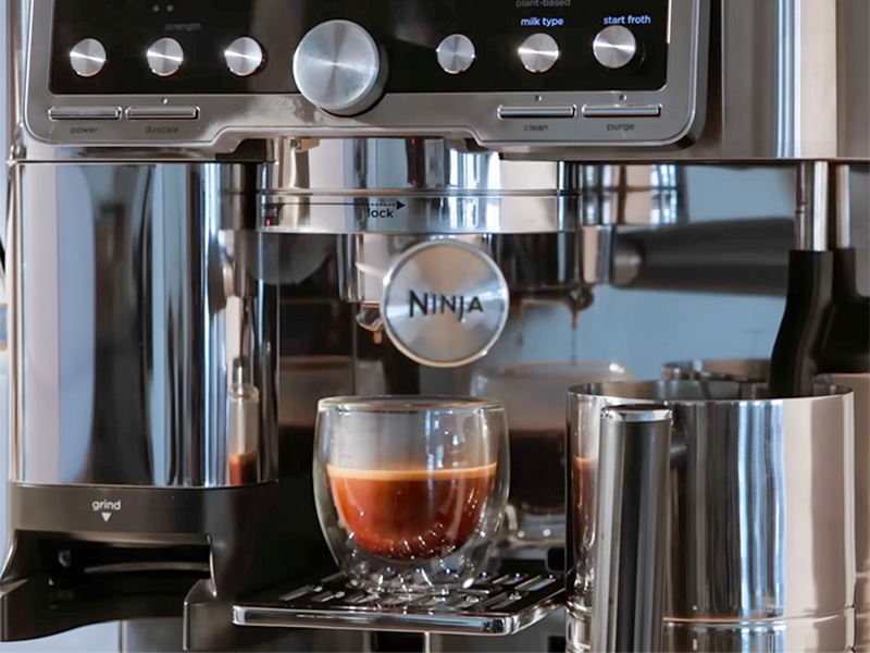 Freshly made espresso shot on the drip tray of the Ninja Luxe Cafe Pro, the last drops falling into the glass
