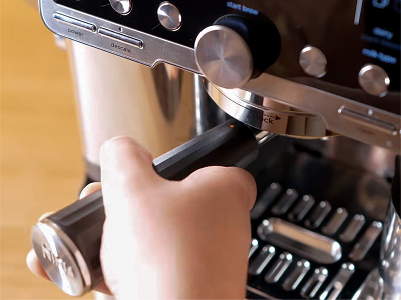 Hand locking the portafilter into place on the Ninja Luxe Cafe Pro