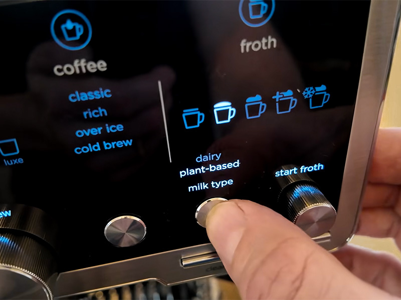 Close-up of hand selecting the milk type and froth level on the Ninja Luxe Cafe Pro (ES701)
