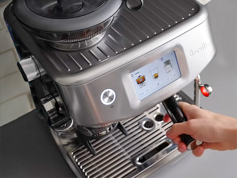 Hand inserting the portafilter into the Breville Barista Touch Impress