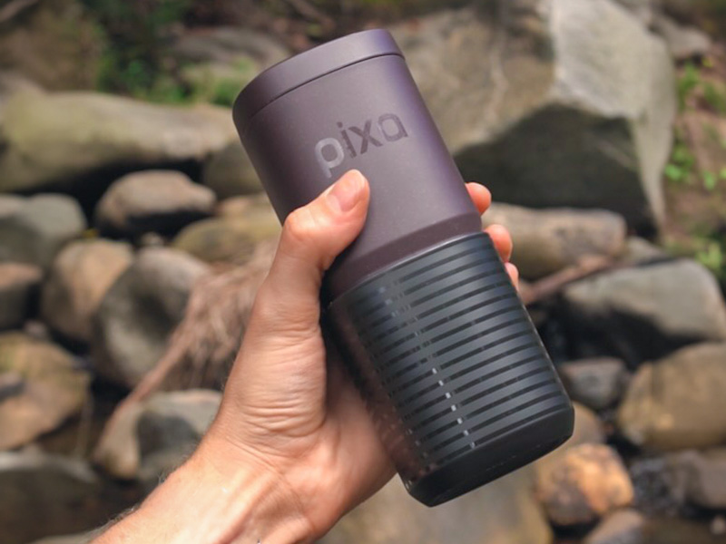 Hand holding the Wacaco Pixapresso with rocks in the background