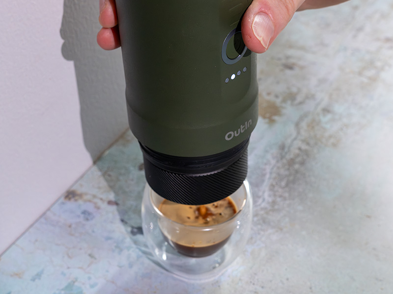 Close-up of pressing the button to make espresso with the OutIn Nano