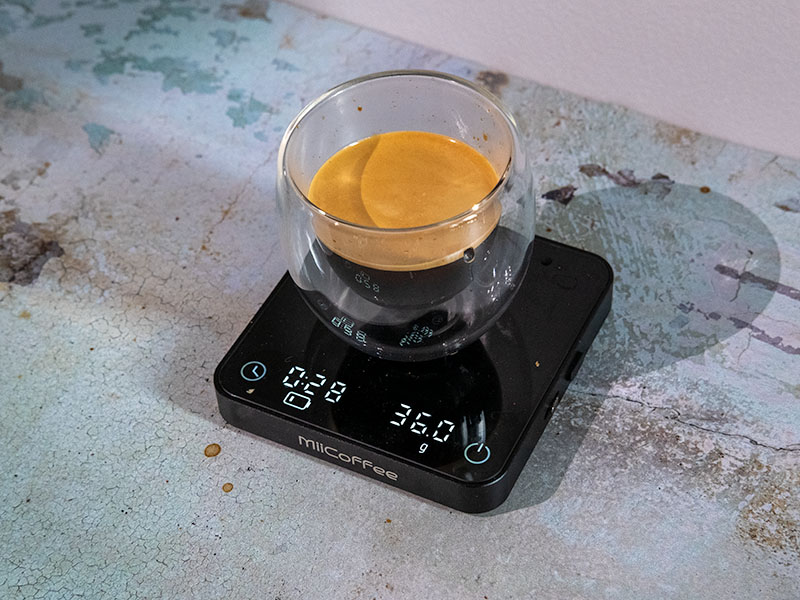 Fresh espresso shot made with the Outin Nano and Basket Plus, sitting on a MiiCoffee scale displaying 28 seconds and 36g
