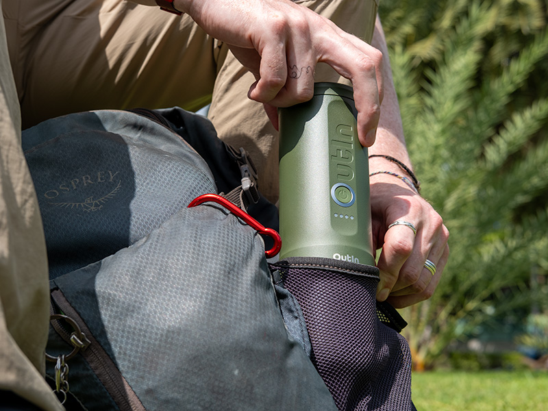 Man taking the Outin Nano out of the side pocket of his backpack whilst hiking