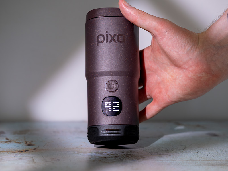 Hand holding the Wacaco Pixapresso, the touchscreen displays '92' meaning the temperature setting is at 92 celsius