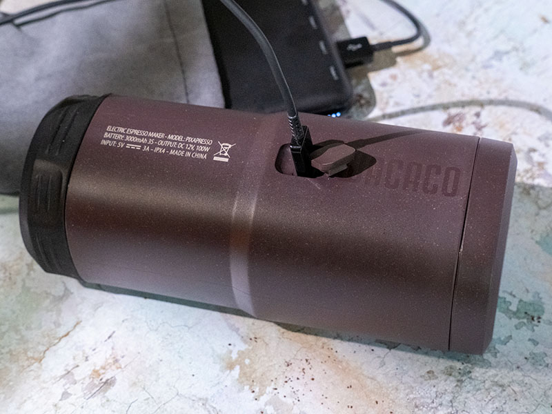 The Wacaco Pixapresso lying on its side, recharging using the USB-C charging slot