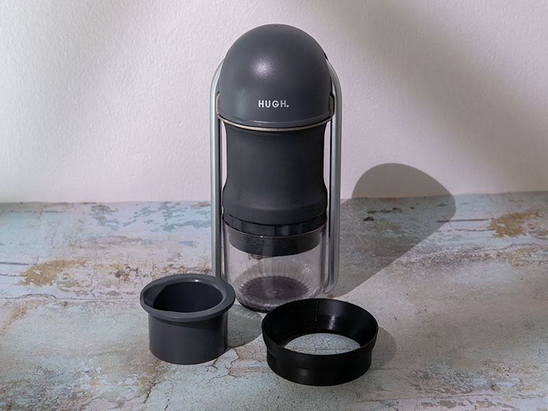 The HUGH Leverpresso Lite V4 sitting on table with the included tamper and dosing funnel in front