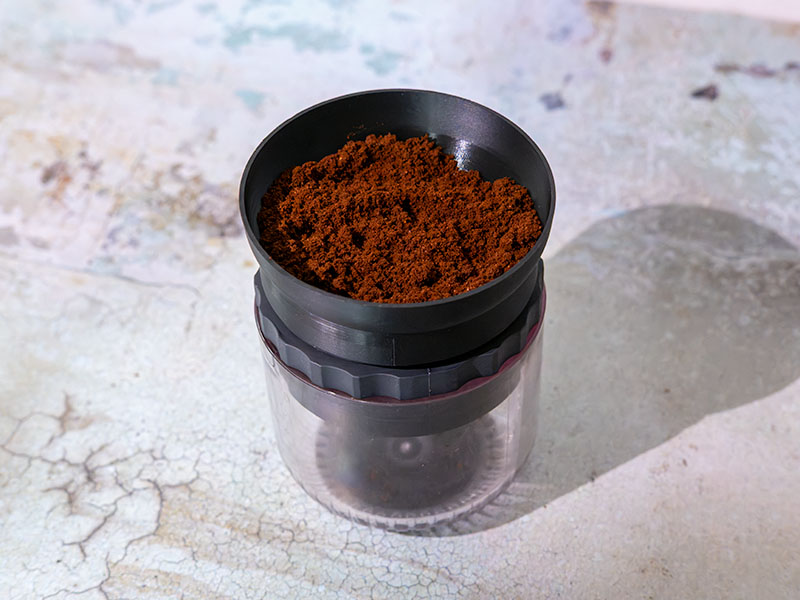 Freshly ground coffee in the grounds basket for the HUGH Leverpresso Lite V4, with the dosing funnel attached