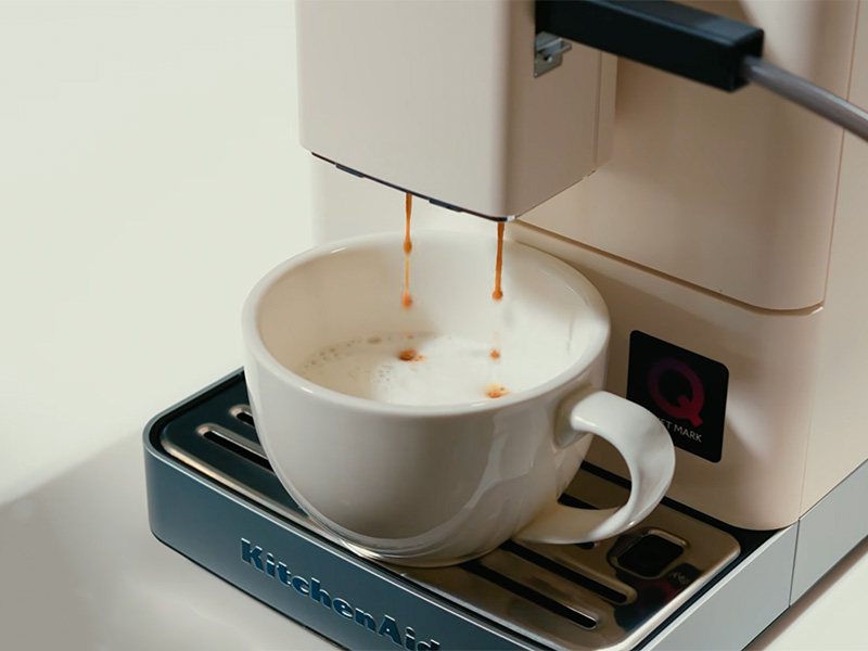 Close-up of the milk texture for a cappuccino made by the KitchenAid KF3, white porcelain cup on the drip tray