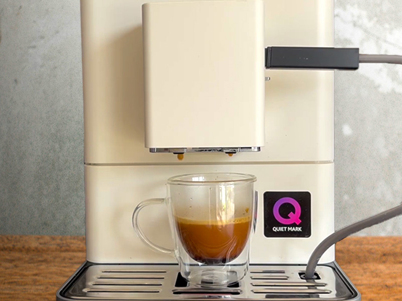 A freshly made shot of espresso sitting on the drip tray of the KitchenAid KF3, a droplet of coffee is about to fall from one of the spouts