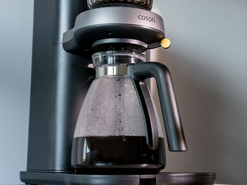 Full carafe of freshly made pour over coffee sittingon the drip tray of the Cosori Juni coffee machine